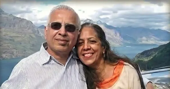 Nazir and Ashraf Bhagat smiling together in front of a mountain lake.